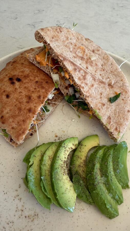 A flatbread sandwich with sliced avocado
