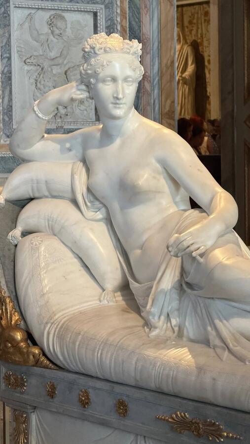 A reclining marble figure on a carved couch