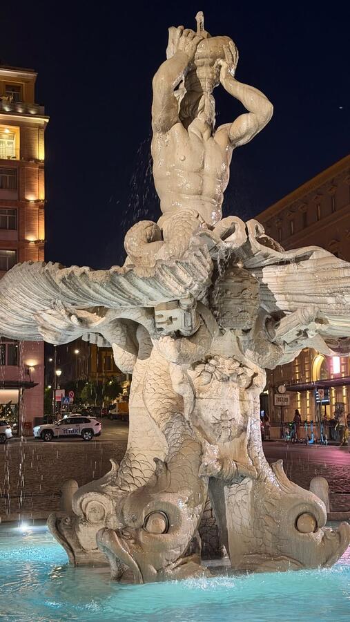 A baroque fountain lit at night